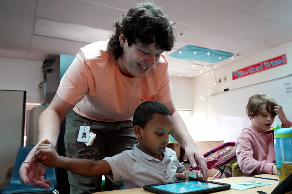 Charlie Argall working as a paraprofessional with early childhood students